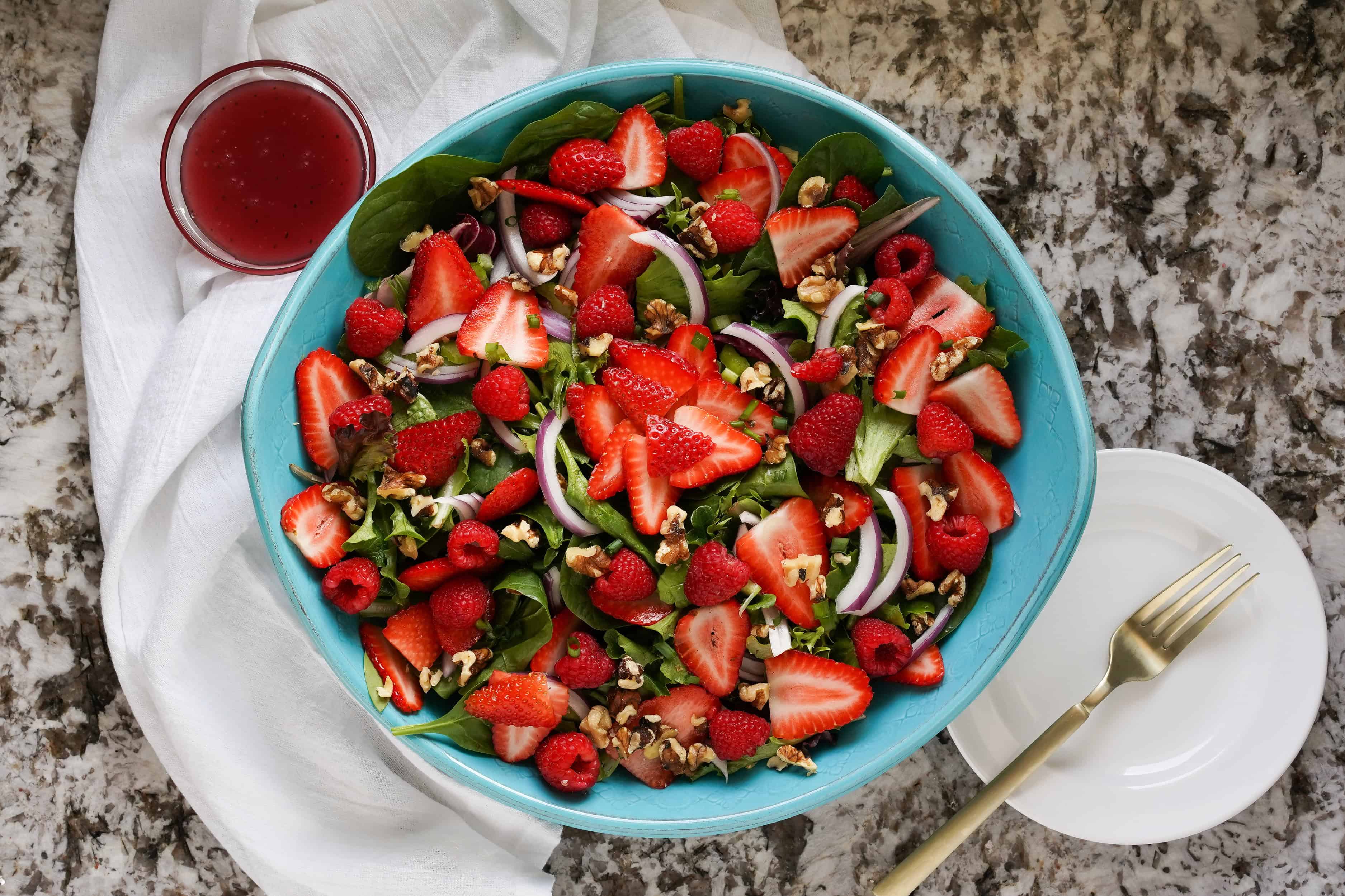 Vue d'ensemble d'une salade d'été avec des framboises et des fraises.