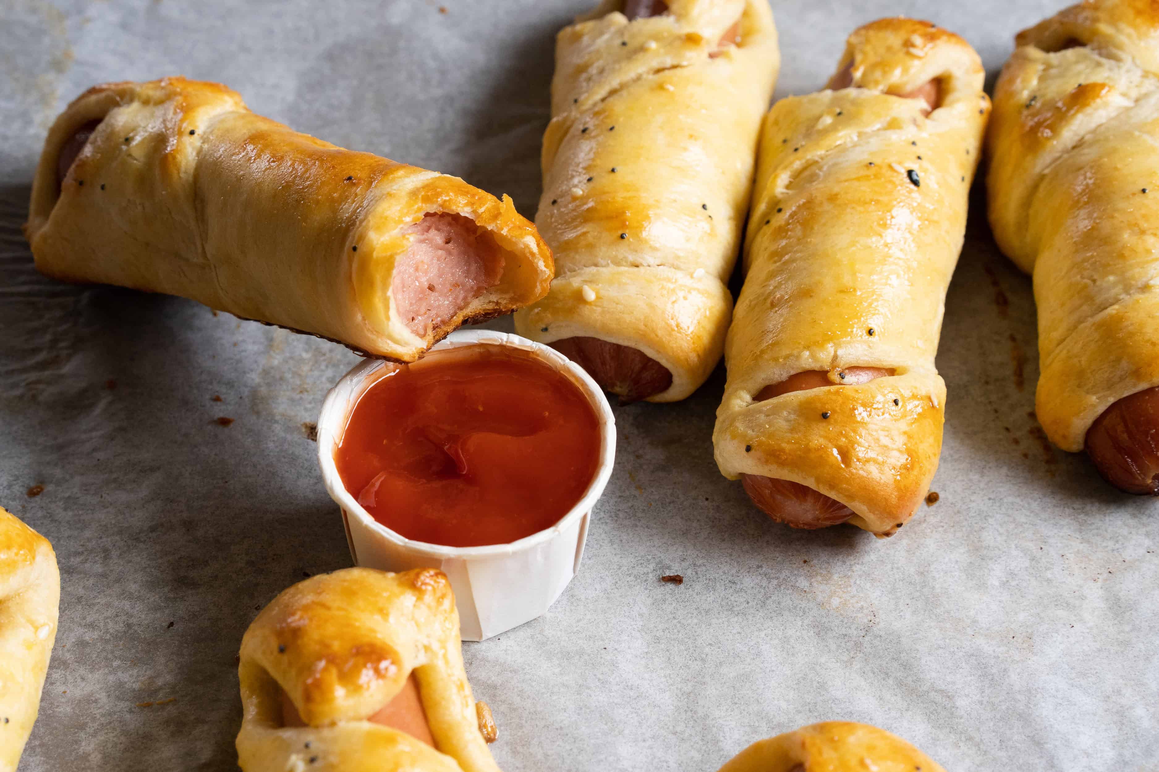 Une bouchée d'une momie enveloppée ou hot-dog cuit dans une pâte feuilletée, chaud et prêt à être dégusté ! Parfait pour les enfants et les adultes !