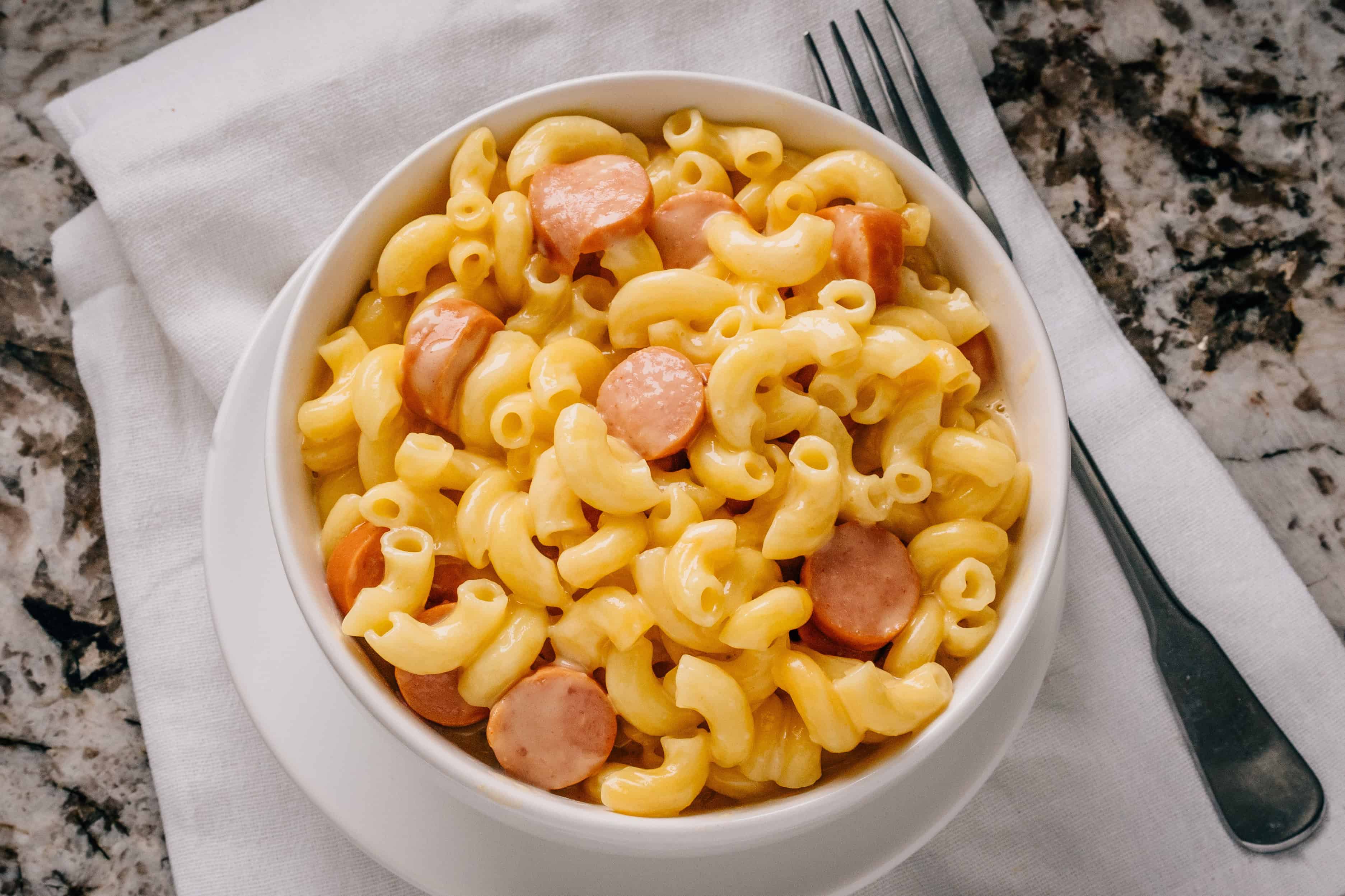 Macaroni au fromage en mijoteuse avec des hot-dogs dans un bol