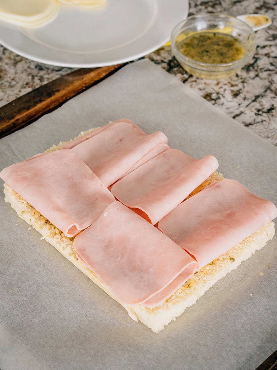 Ensuite, j'ai plié le jambon sur le dessus de la partie beurrée des petits pains. J'ai utilisé 5 tranches mais vous pouvez ajouter autant de jambon que vous préférez.