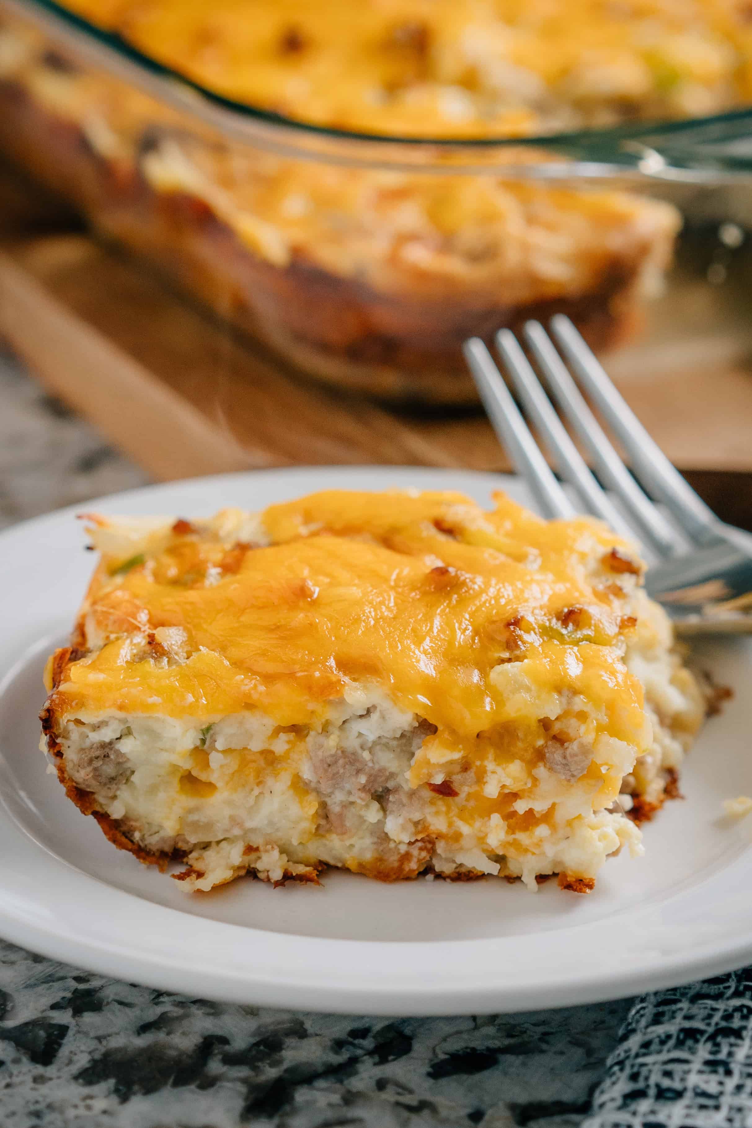 Une portion de ce gâteau de petit déjeuner facile préparé avec de la saucisse, des pommes de terre rissolées et des poivrons verts.