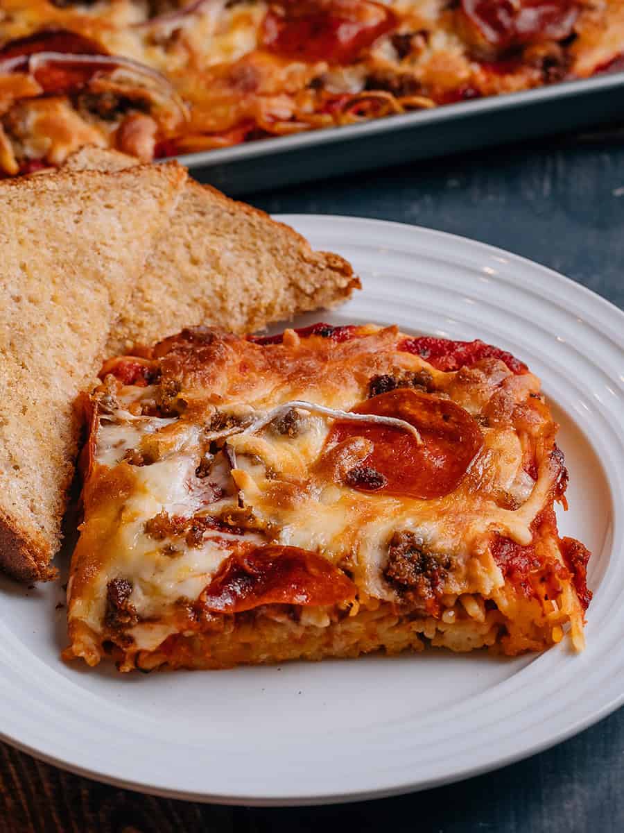 Spaghetti à la pizza servi avec du pain à l'ail.