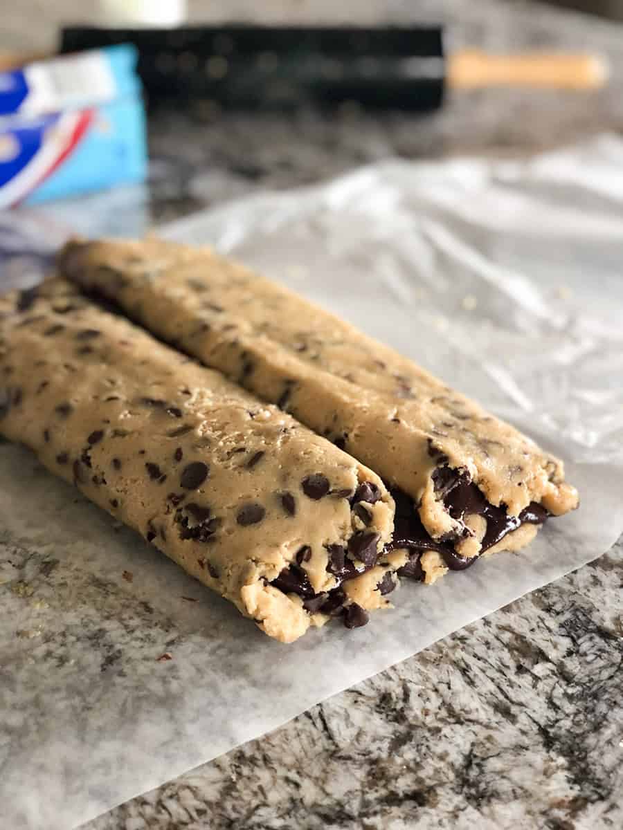 La feuille de pâte à cookies et de pâte à brownie roulée des deux côtés pour se rencontrer au centre, formant deux boudins connectés au milieu.