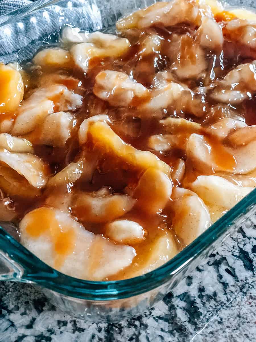 Gros plan sur la garniture de tarte aux pommes arrosée de sirop de caramel.