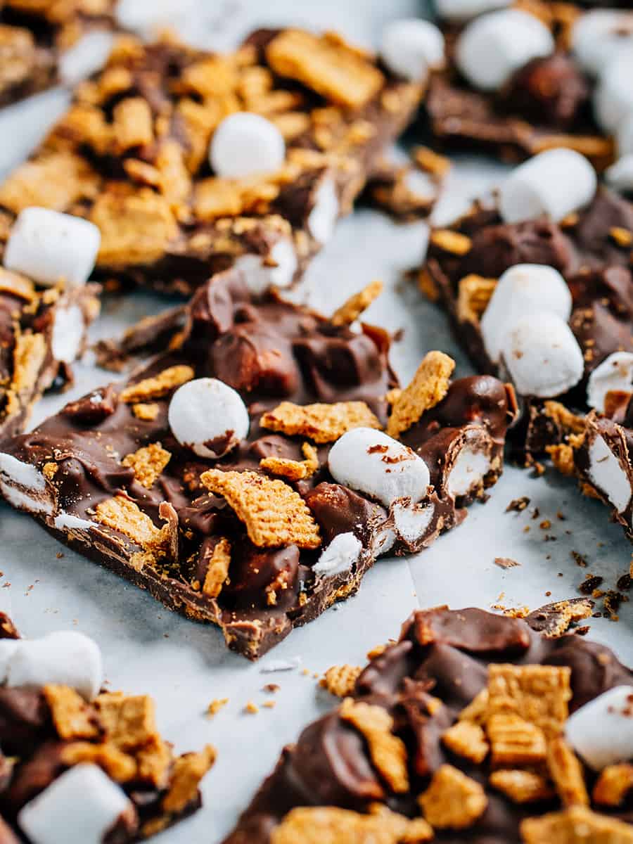 Gros plan d'un morceau de s'mores bark où l'on peut voir le chocolat au lait recouvrant les mini guimauves et les golden grahams.