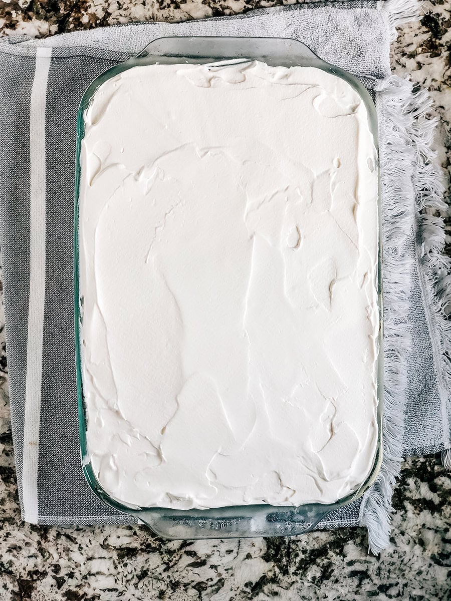 Surmontez le gâteau de glace avec une couche de garniture fouettée épaisse.