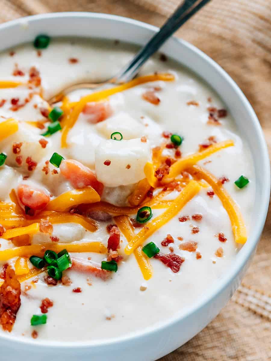 Un bol plein de soupe de pommes de terre au fromage à la crème prêt à être dégusté.