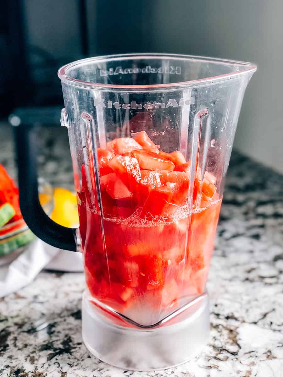 Pastèque congelée en cubes et 2 tasses de limonade dans un récipient de mixeur.