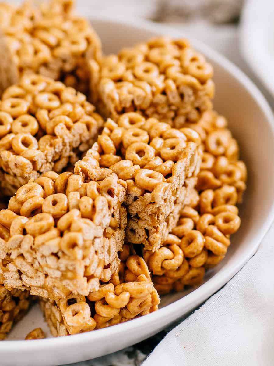 Une vue rapprochée de ces délicieuses barres de Cheerios au beurre de cacahuète dans un plat de service.