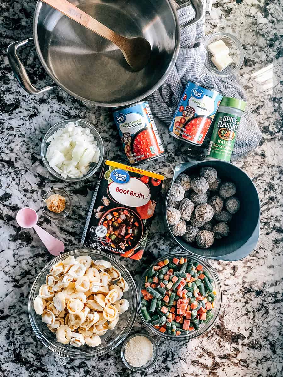 Boulettes de viande congelées, tortellini au fromage et légumes, bouillon de bœuf, oignon haché, ail émincé, tomates en dés petites, et assaisonnement italien : Les ingrédients de cette soupe de boulettes de viande italiennes et de tortellini au fromage.