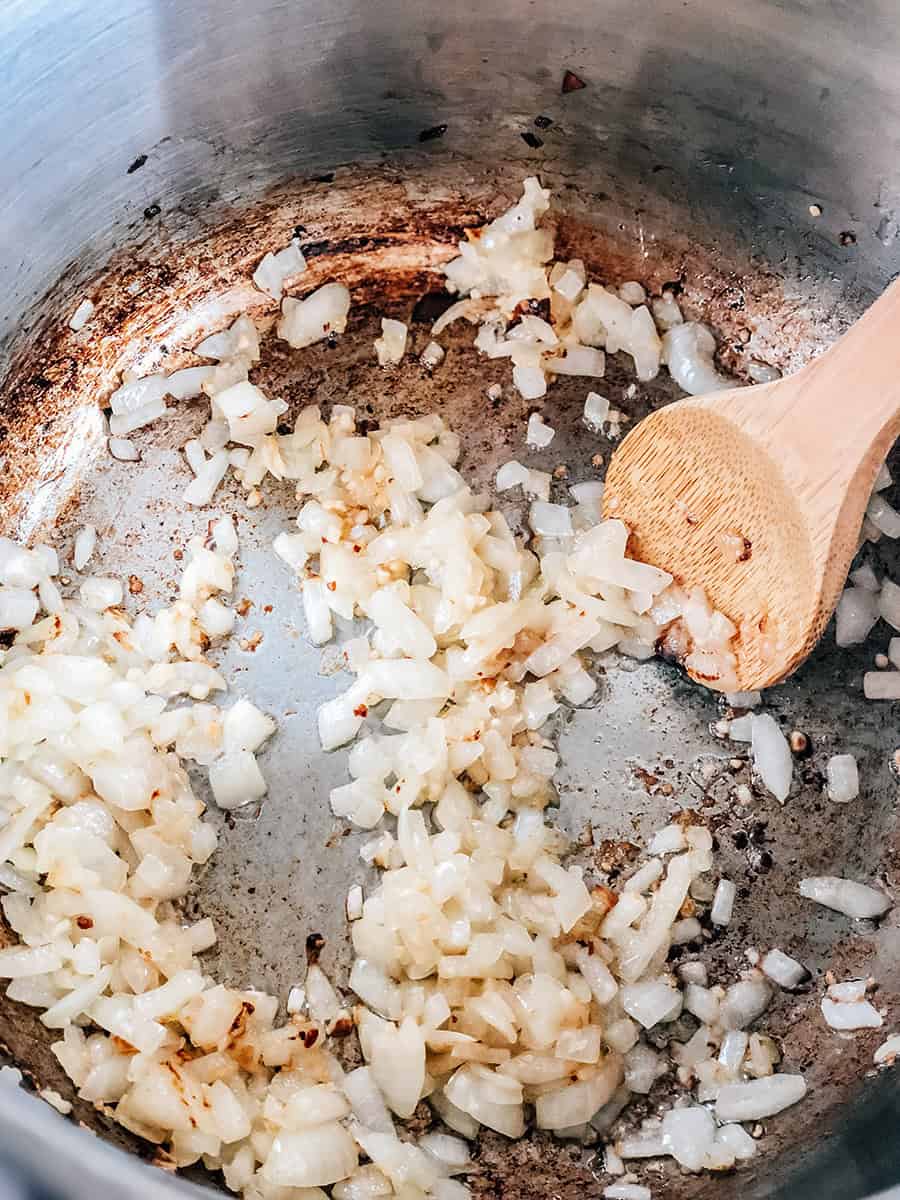 Oignons et ail dorés dans une grande casserole.