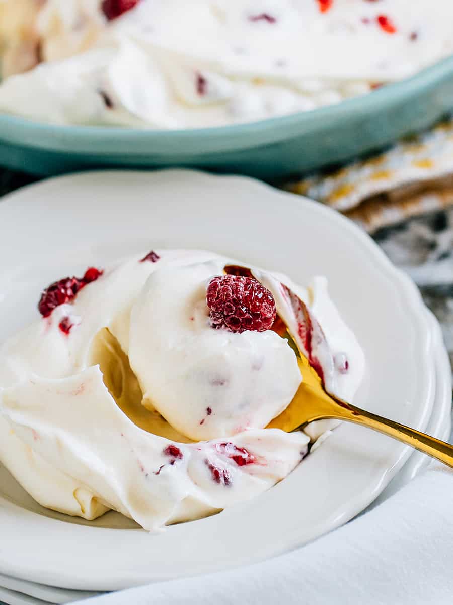 Portion individuelle de fluff aux framboises avec une framboise congelée sur le dessus.