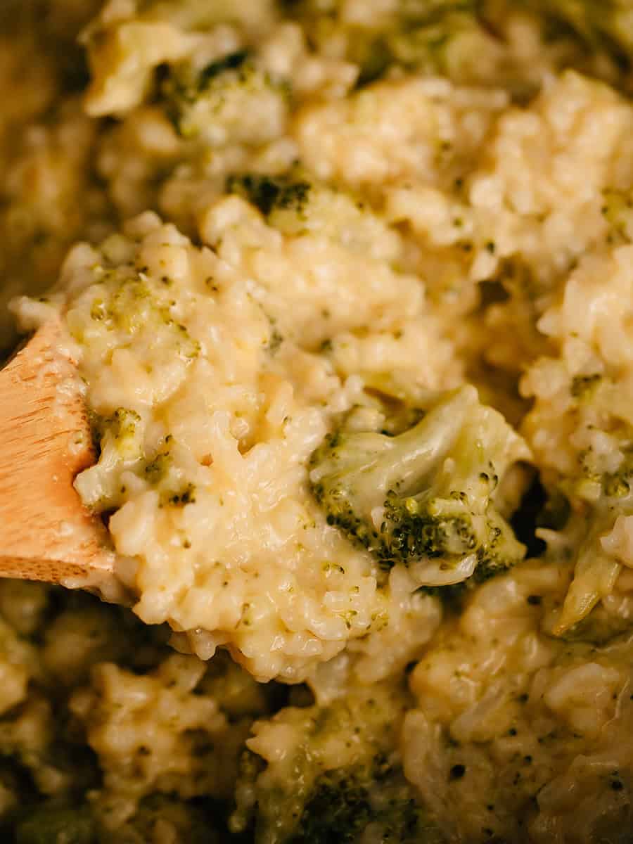 Une cuillère pleine de gratin crémeux de brocoli et fromage.