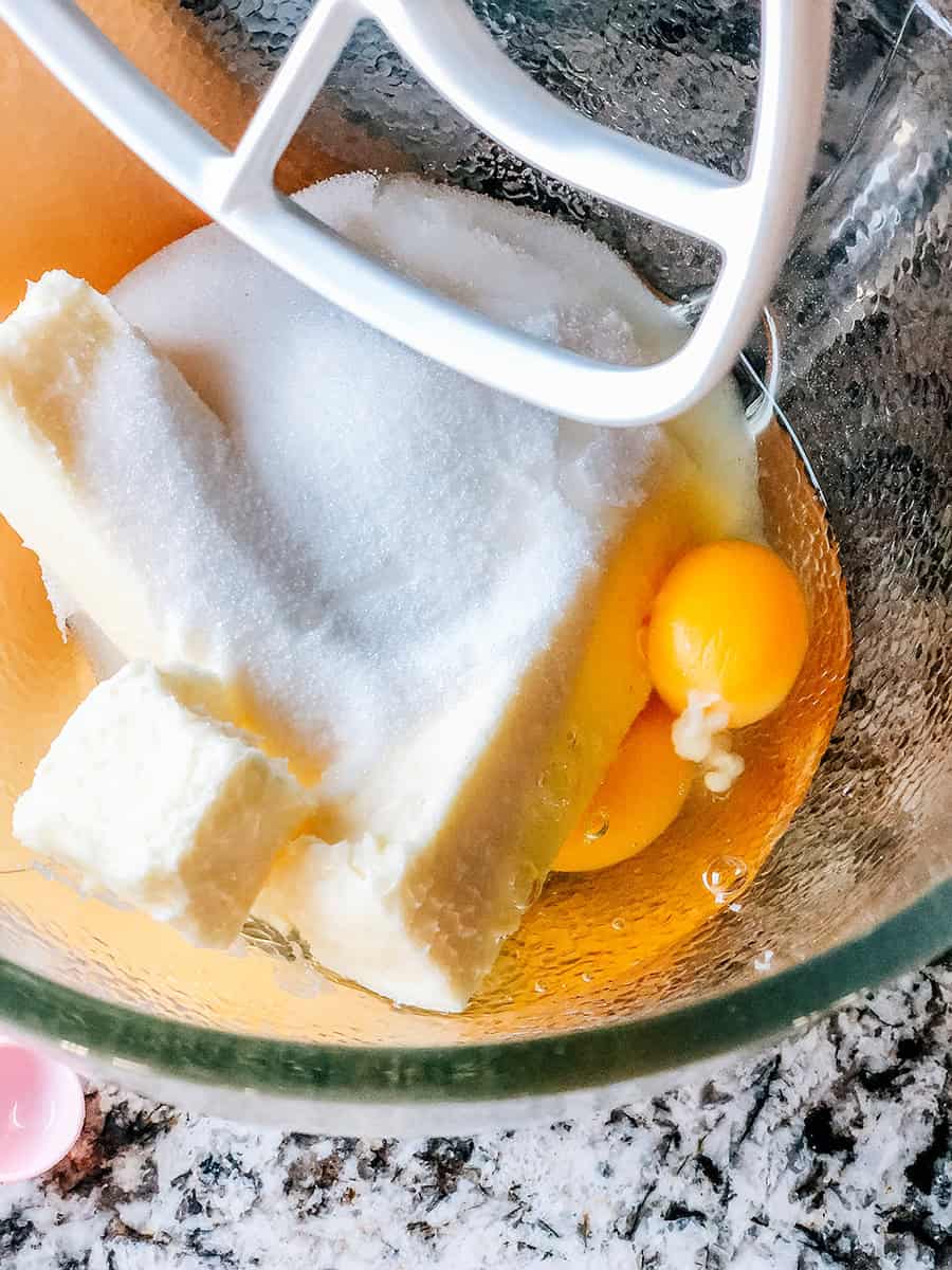 Gros plan sur du beurre, du sucre et des œufs prêts à être mélangés dans un robot pâtissier.