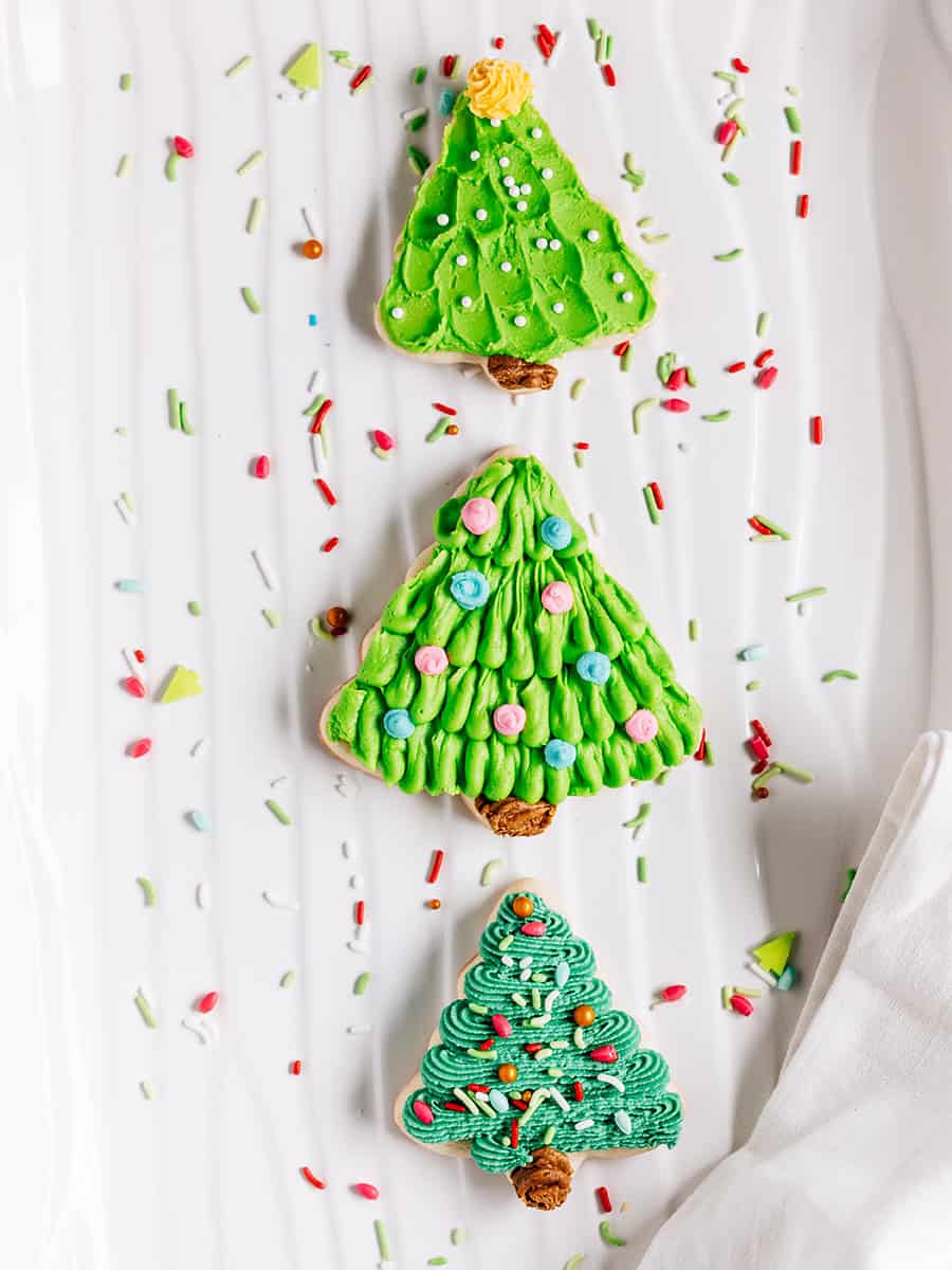 Biscuits en forme de sapin de Noël avec une touche de citron sur une assiette.