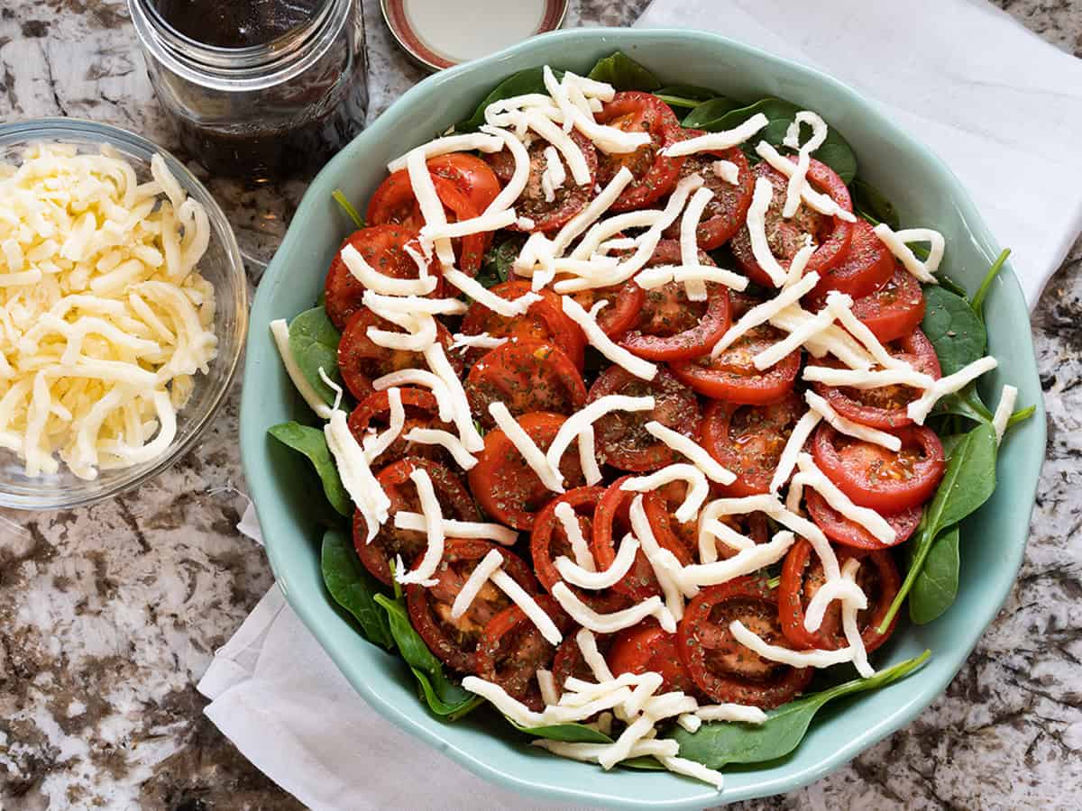 Épinards croustillants, tomates Roma fraîches, basilic séché et mozzarella superposés.