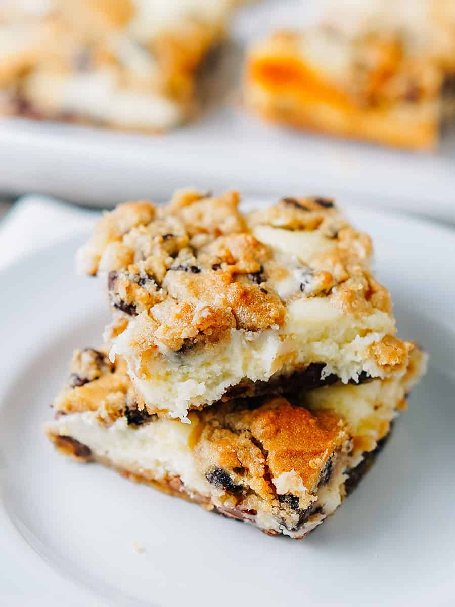 Avec une garniture de cheesecake crémeux et de délicieux biscuits aux pépites de chocolat en haut et en bas, ces barres de dessert sont savoureuses !