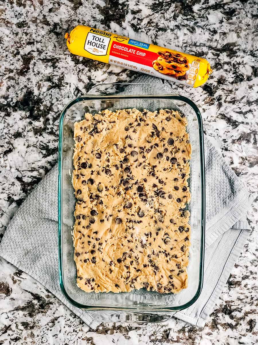 Étape un : Aplatir la pâte à biscuits aux pépites de chocolat dans le fond d'un moule à gâteau.