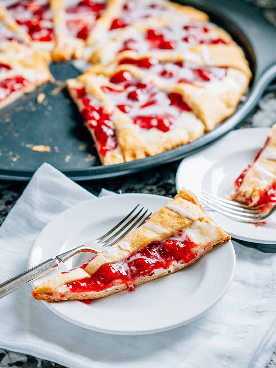 Une tranche de dessert en couronne de croissants aux cerises et au fromage à la crème.