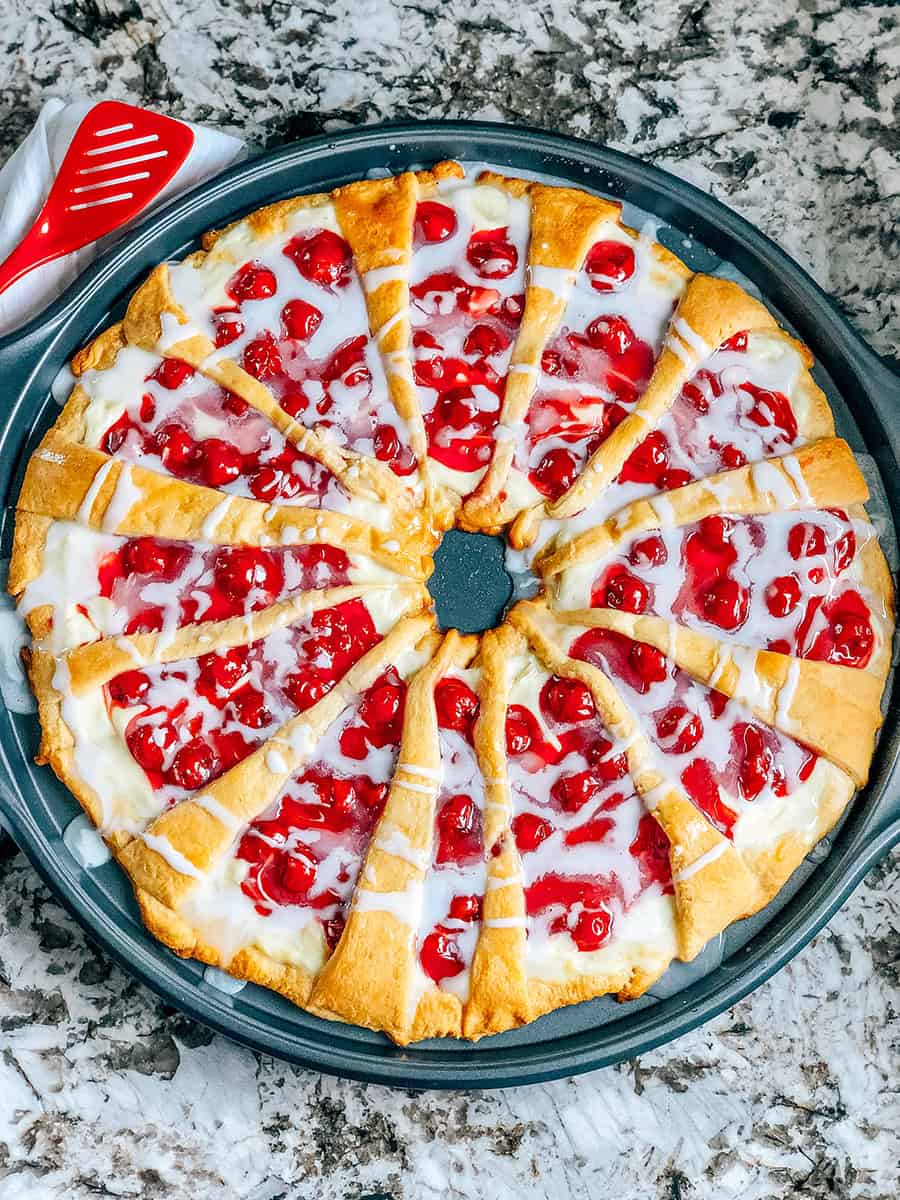 Vue d'ensemble de ce délicieux dessert en couronne de croissants aux cerises et au fromage à la crème avec un glaçage sucré fait maison.