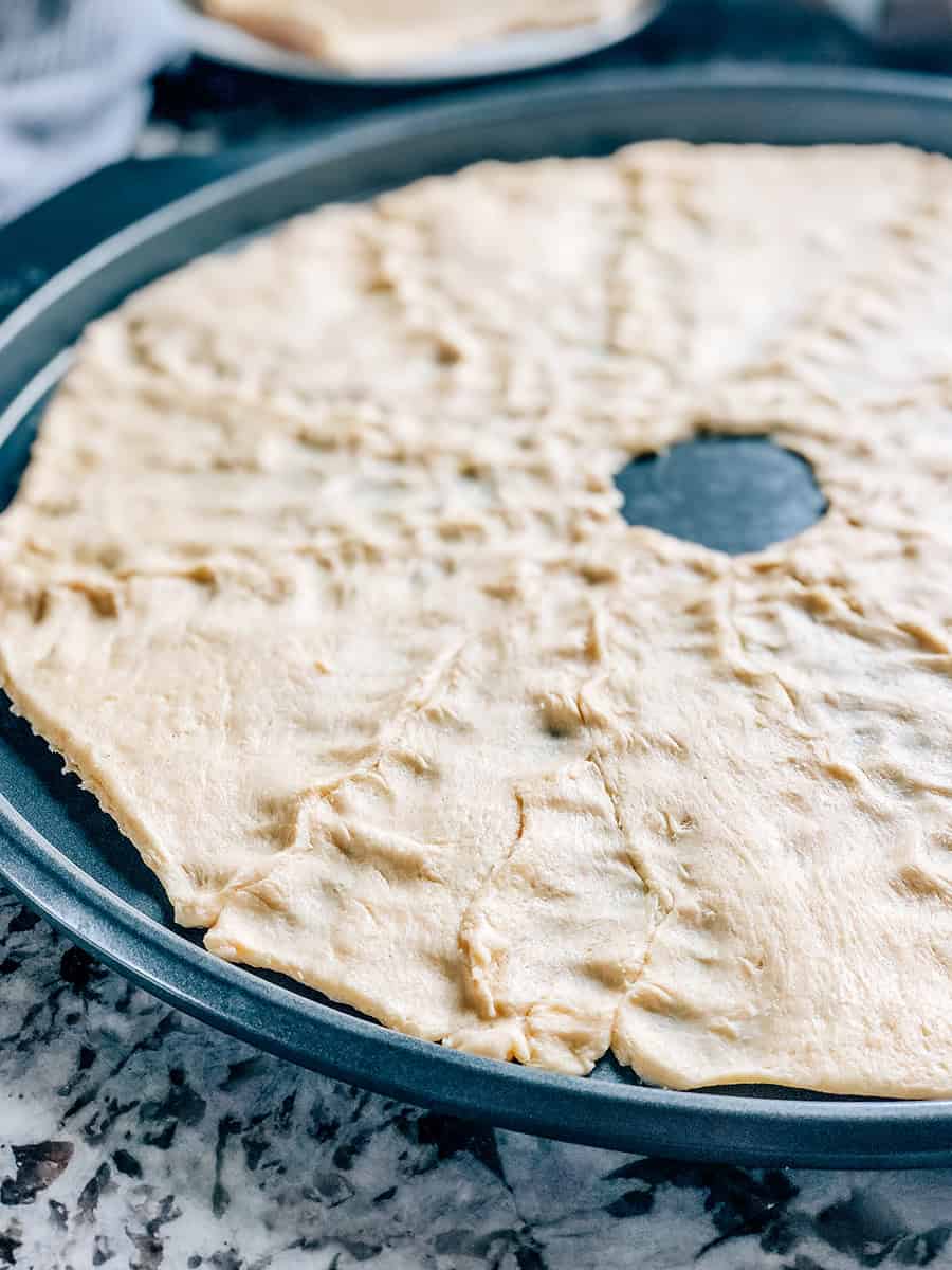 Gros plan des douze rouleaux croissants pincés ensemble pour former la croûte de cette couronne de croissants aux cerises et au fromage à la crème.