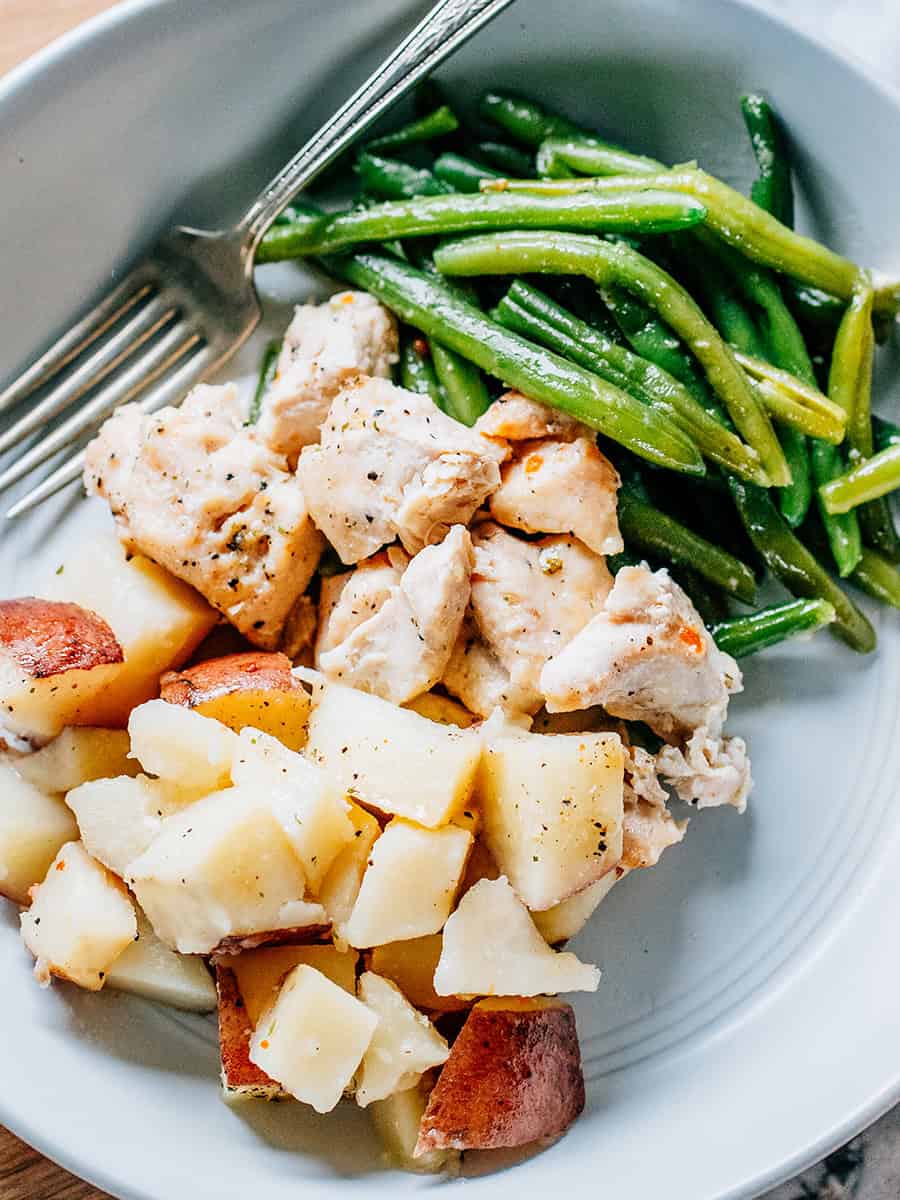 Poulet cuit, haricots verts et pommes de terre assaisonnés avec un sachet de vinaigrette italienne, chauds et prêts à être mangés !