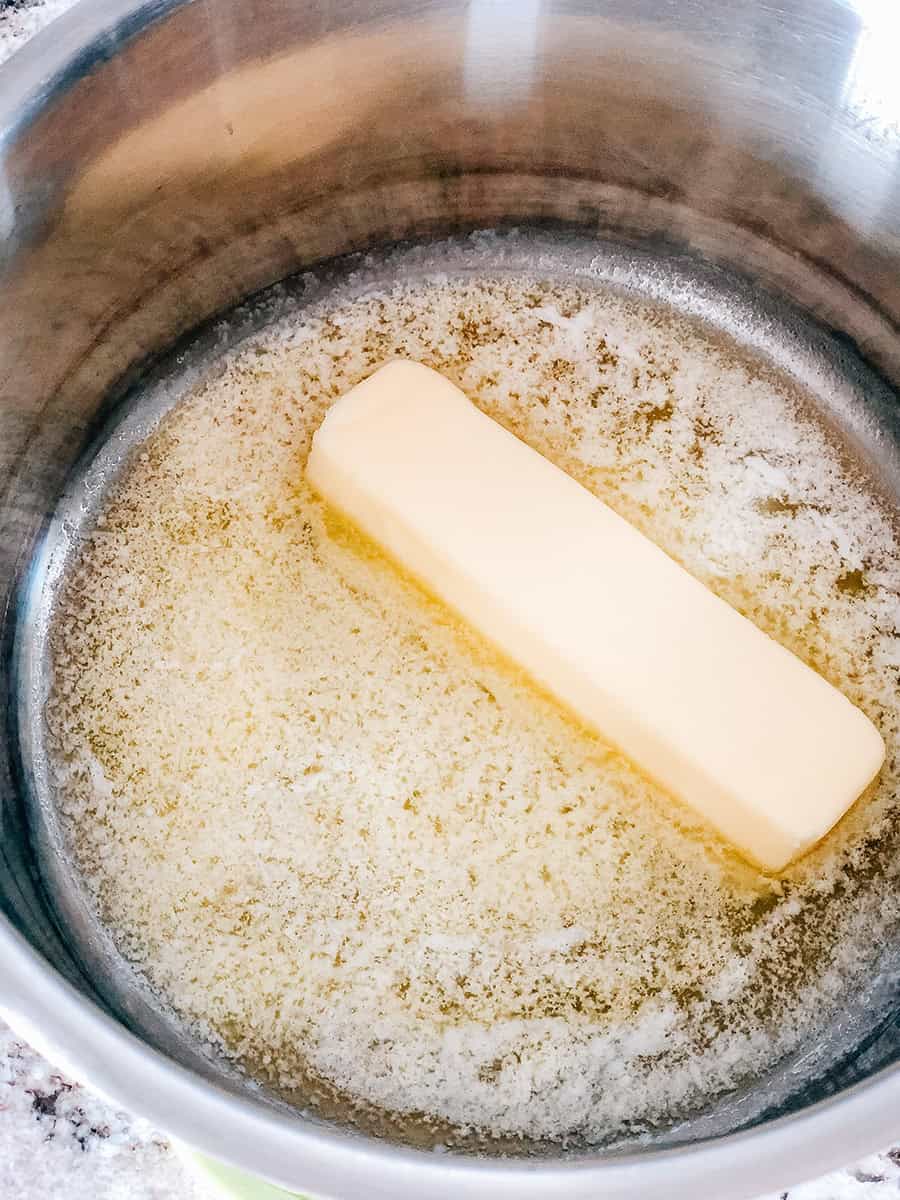 Un morceau de beurre fondant dans une grande casserole.