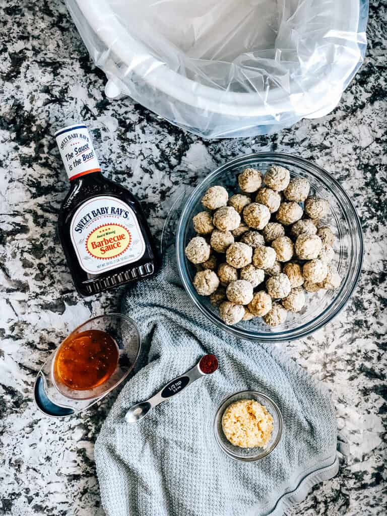 Aperçu des ingrédients des délicieuses boulettes de viande en cocotte : sauce barbecue, miel, ail haché, poivre de Cayenne et boulettes de viande traditionnelles.