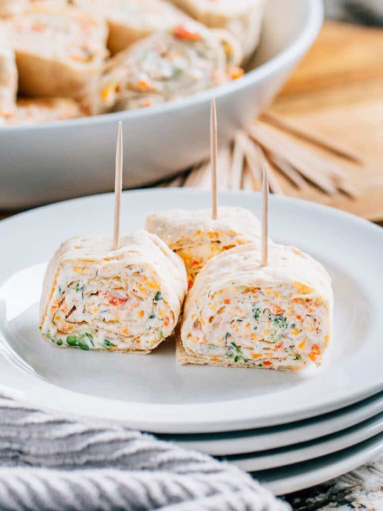 Une assiette de service unique avec trois rouleaux de légumes.