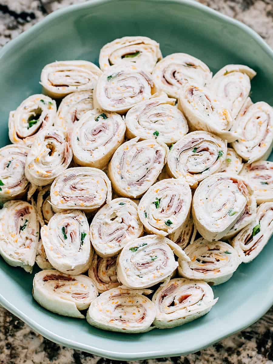 Une assiette de délicieux rouleaux de jambon et fromage empilés et prêts à être servis.