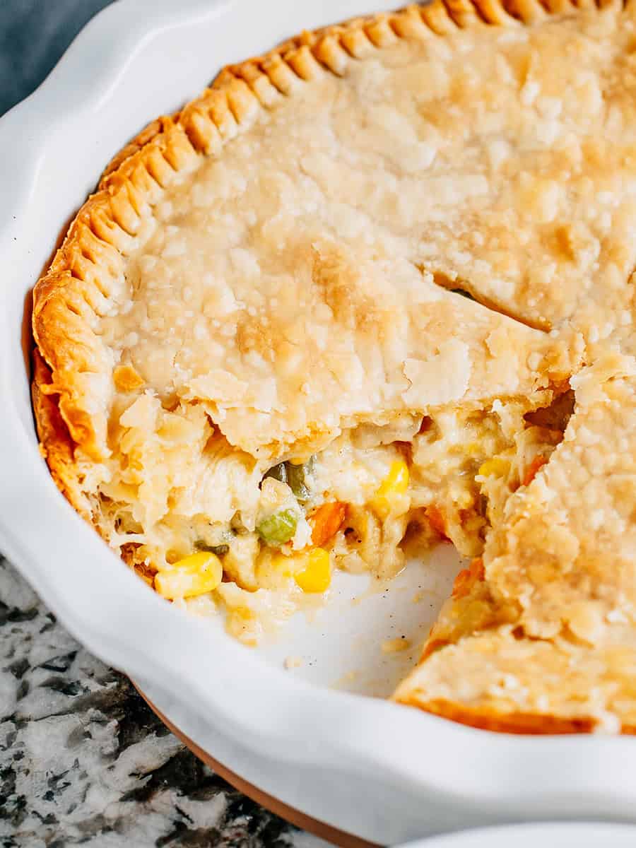 The inside view of a chicken pot pie with shredded chicken, cheddar cheese and vegetables.