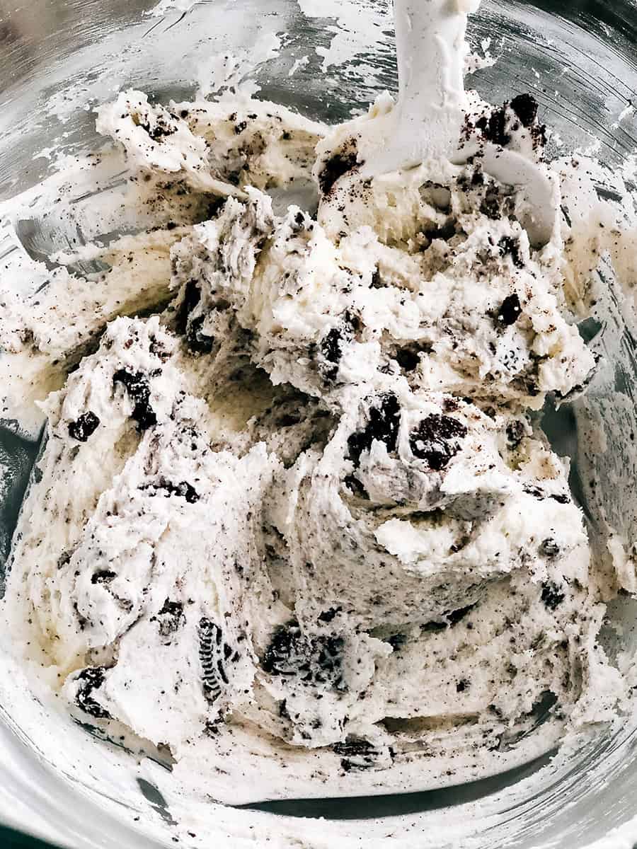 Glaçage blanc et moelleux avec des miettes d'Oreo, le glaçage préparé pour cette recette de biscuits crème et chocolat.