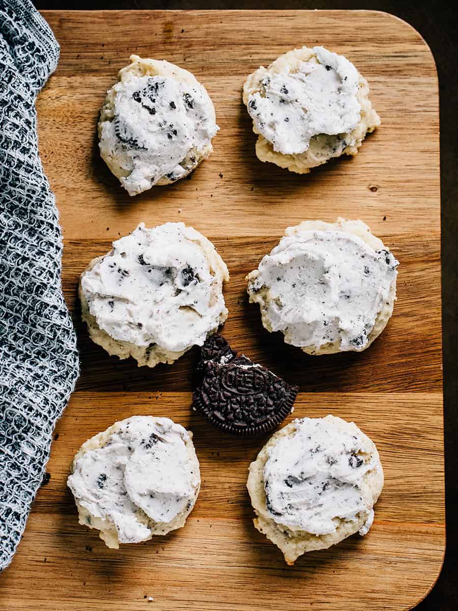 Six biscuits d'une cuillère glacés à côté d'un biscuit Oreo pour référence de taille.