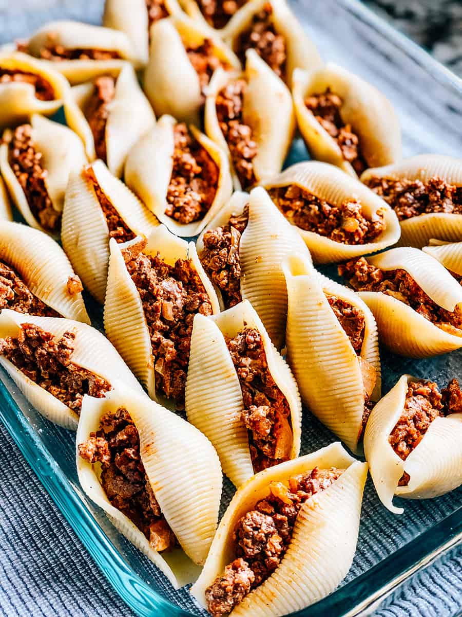 Gros plan sur les grosses coquilles de pâtes cuites farcies à la viande à tacos.