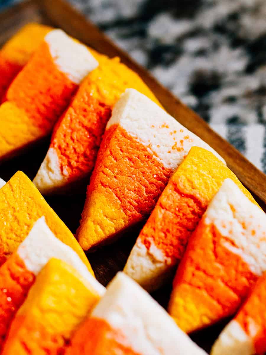 Une rangée de biscuits en forme de bonbons de maïs sur un plateau de desserts.