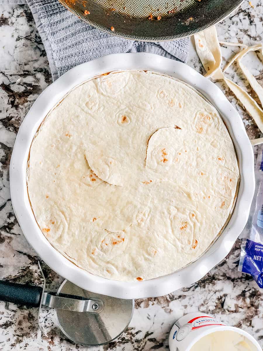 Surmontez avec une croûte de tortilla de farine et ajustez à la taille.