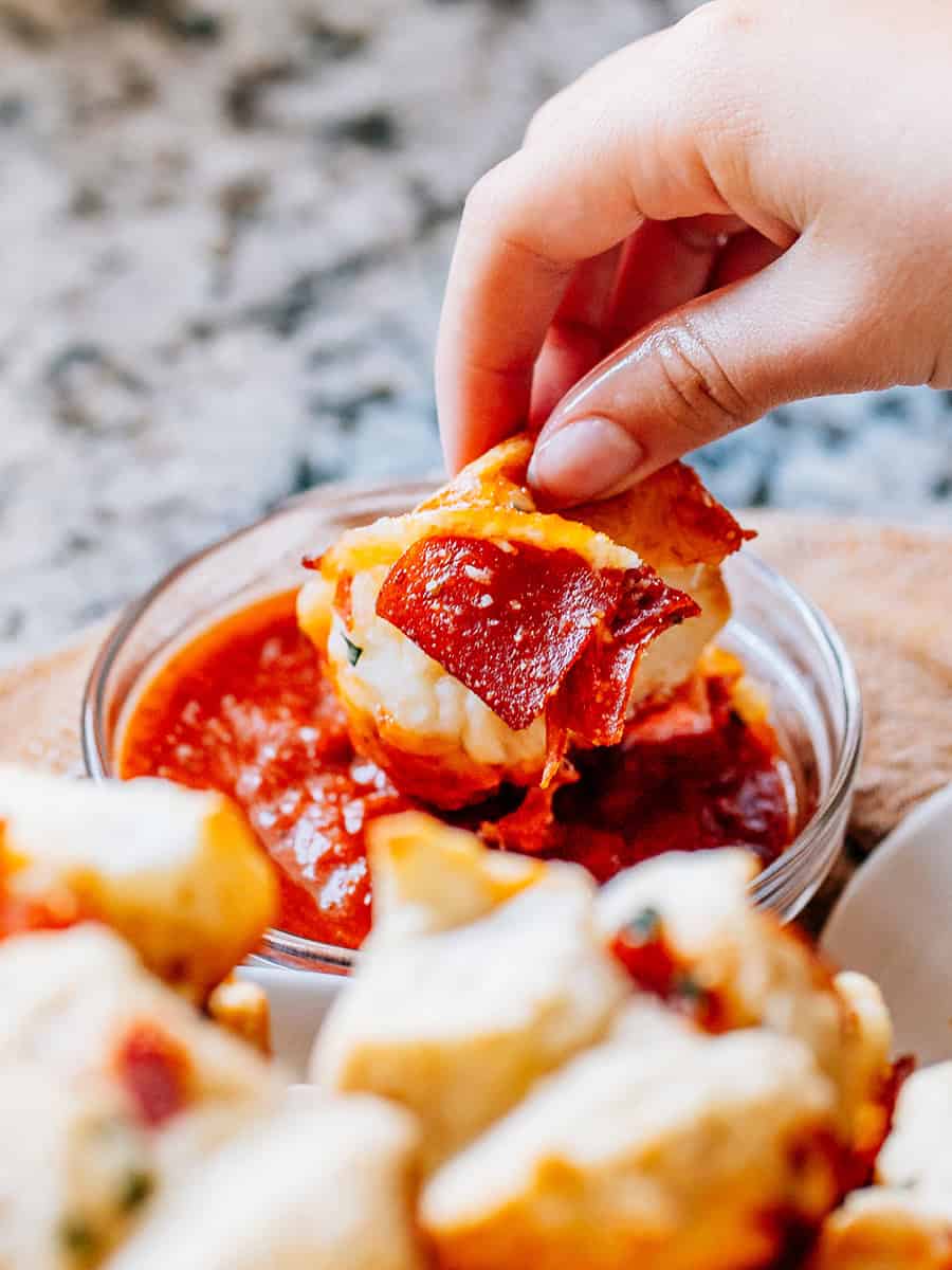 Un muffin à pizza à déchirer trempé dans la sauce marinara, pour un amuse-bouche parfait.