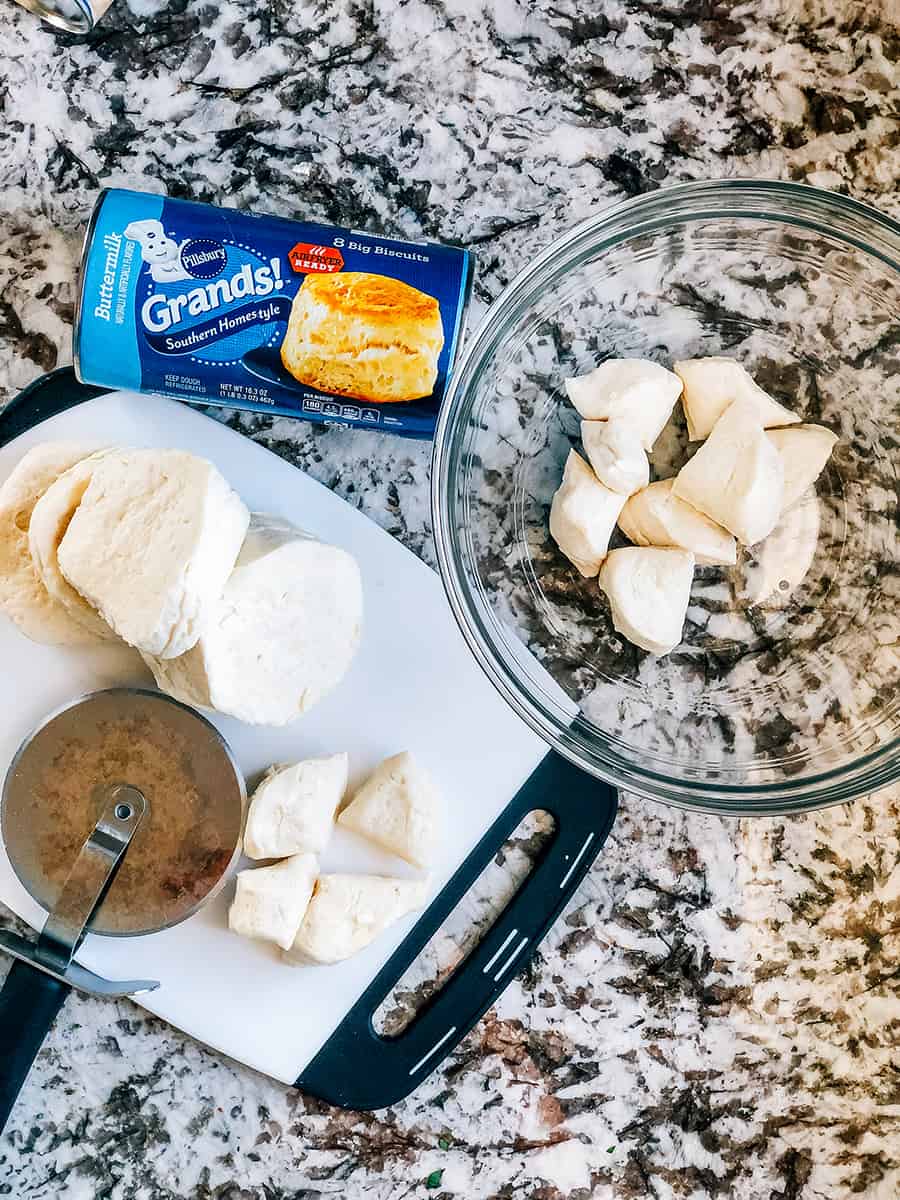 Une planche à découper avec des biscuits Grands coupés en 4 pour les muffins à pizza à déchirer.