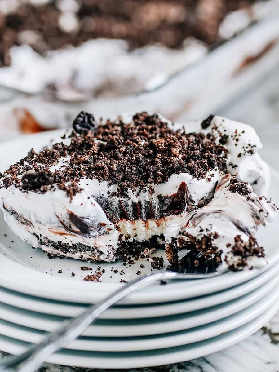 Dessert Oreo Dirt sur assiette avec des couches de délicieux fromage à la crème fouetté, croûte de miettes d'Oreo et pudding au chocolat.