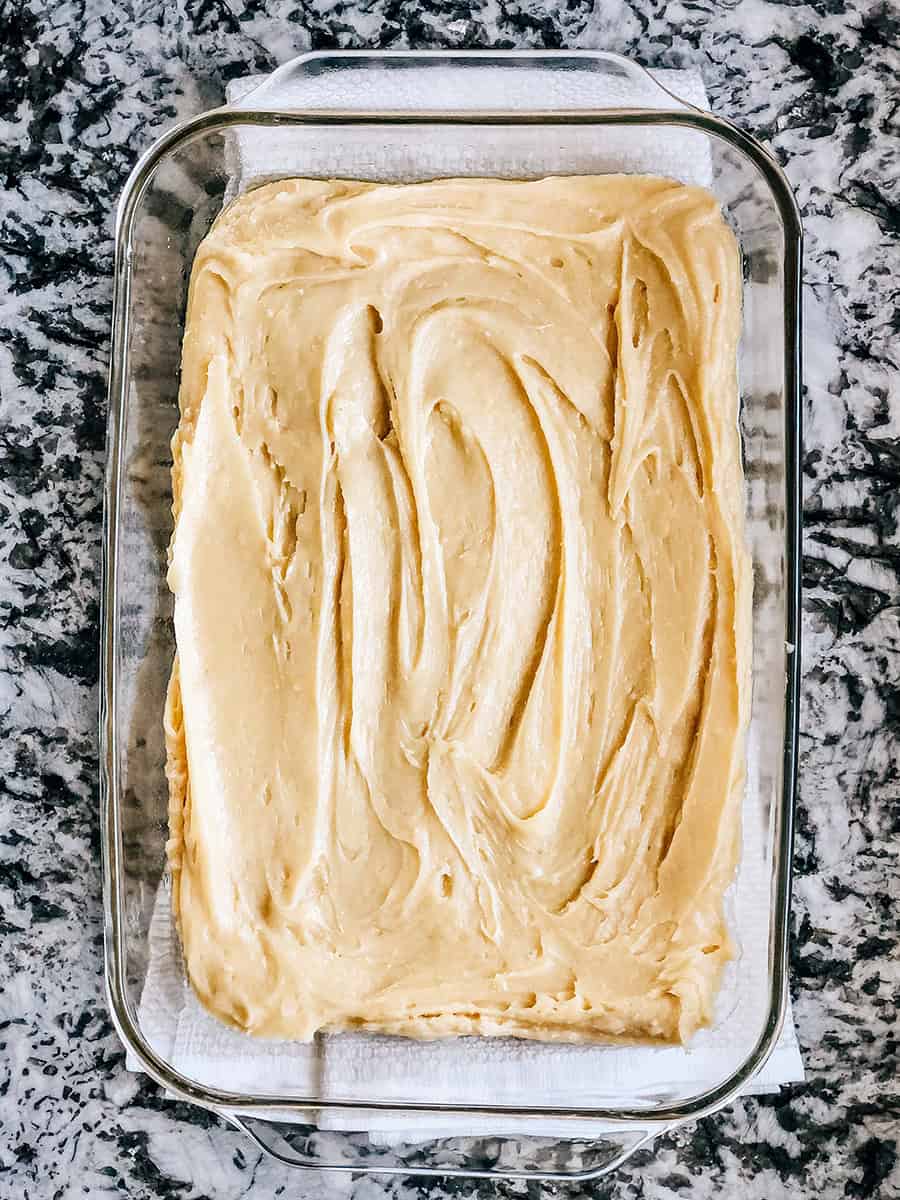 Pâte Snickerdoodle étalée dans un plat de cuisson clair de 9x13 pouces.