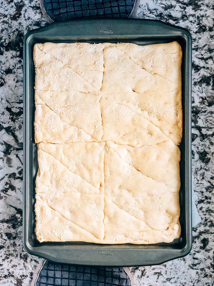 Croûte de pâte à croissant cuite, légère, aérée et dorée pour pizza légumes.