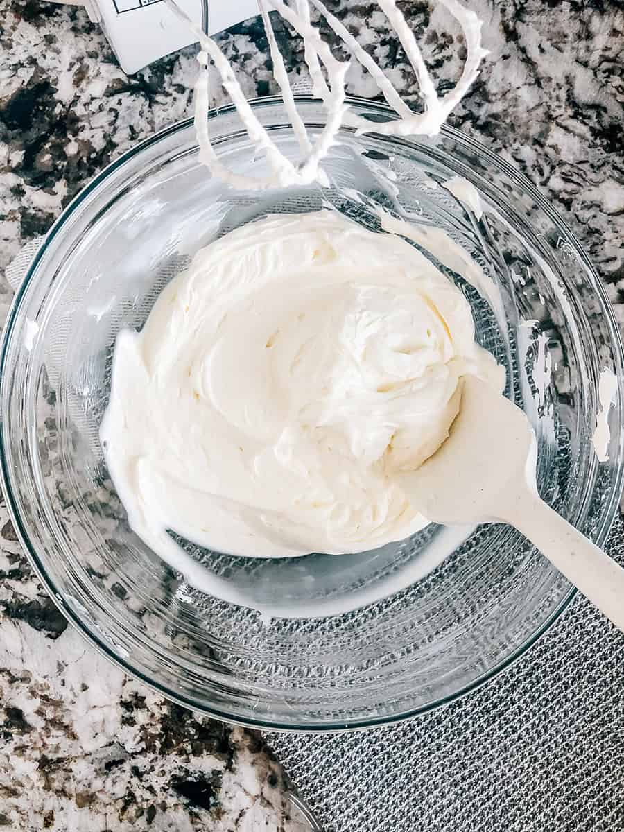 Crème aigre et fromage à la crème battus jusqu'à obtenir une consistance lisse dans un bol moyen.