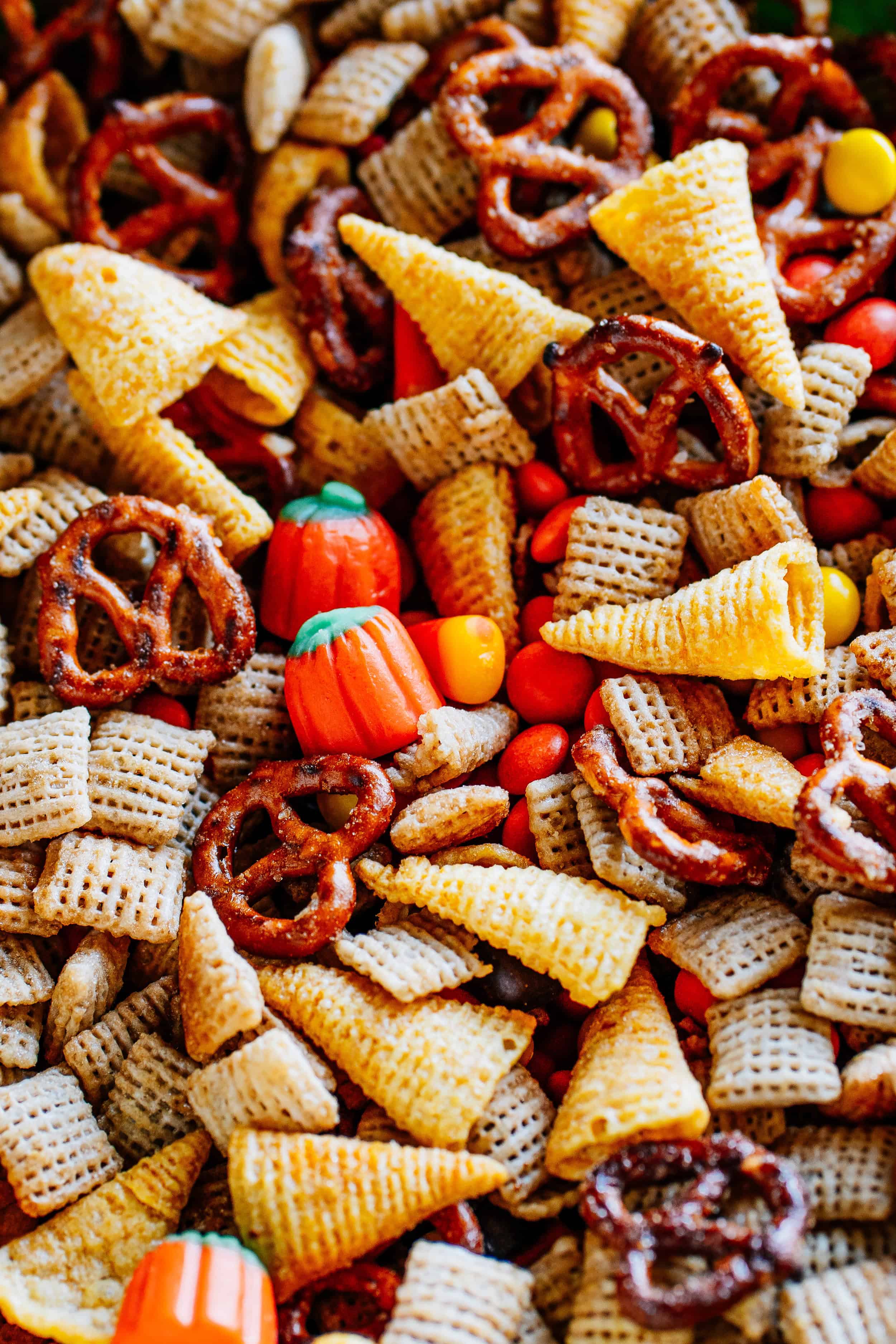 Simple, sweet and salty snack mix with rice squares, Bugles, pretzel twists, candy corn, candy pumpkins, and Reese's Pieces.