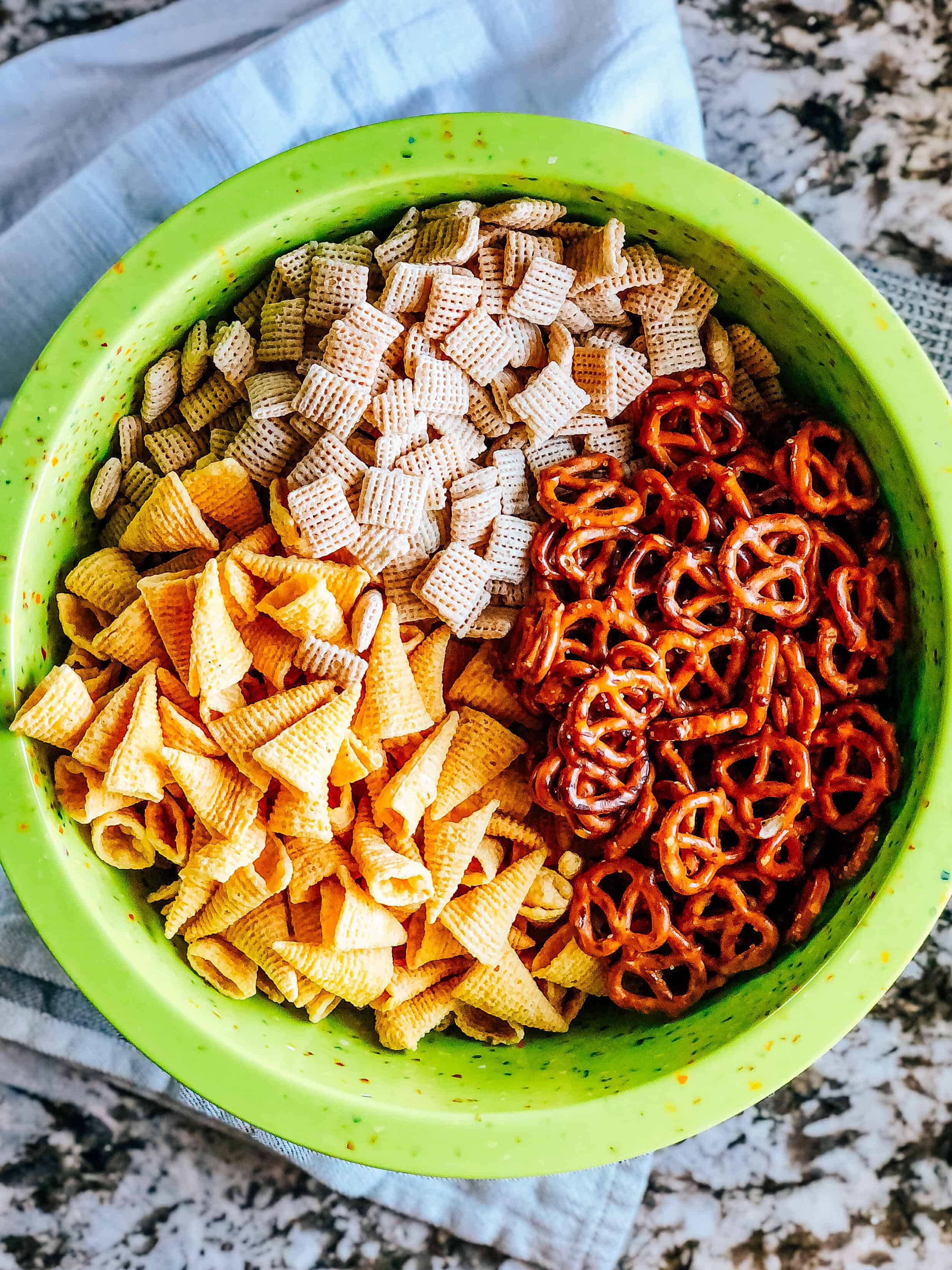 Bugles, rice squares and mini pretzel twists in a extra large mixing bowl.