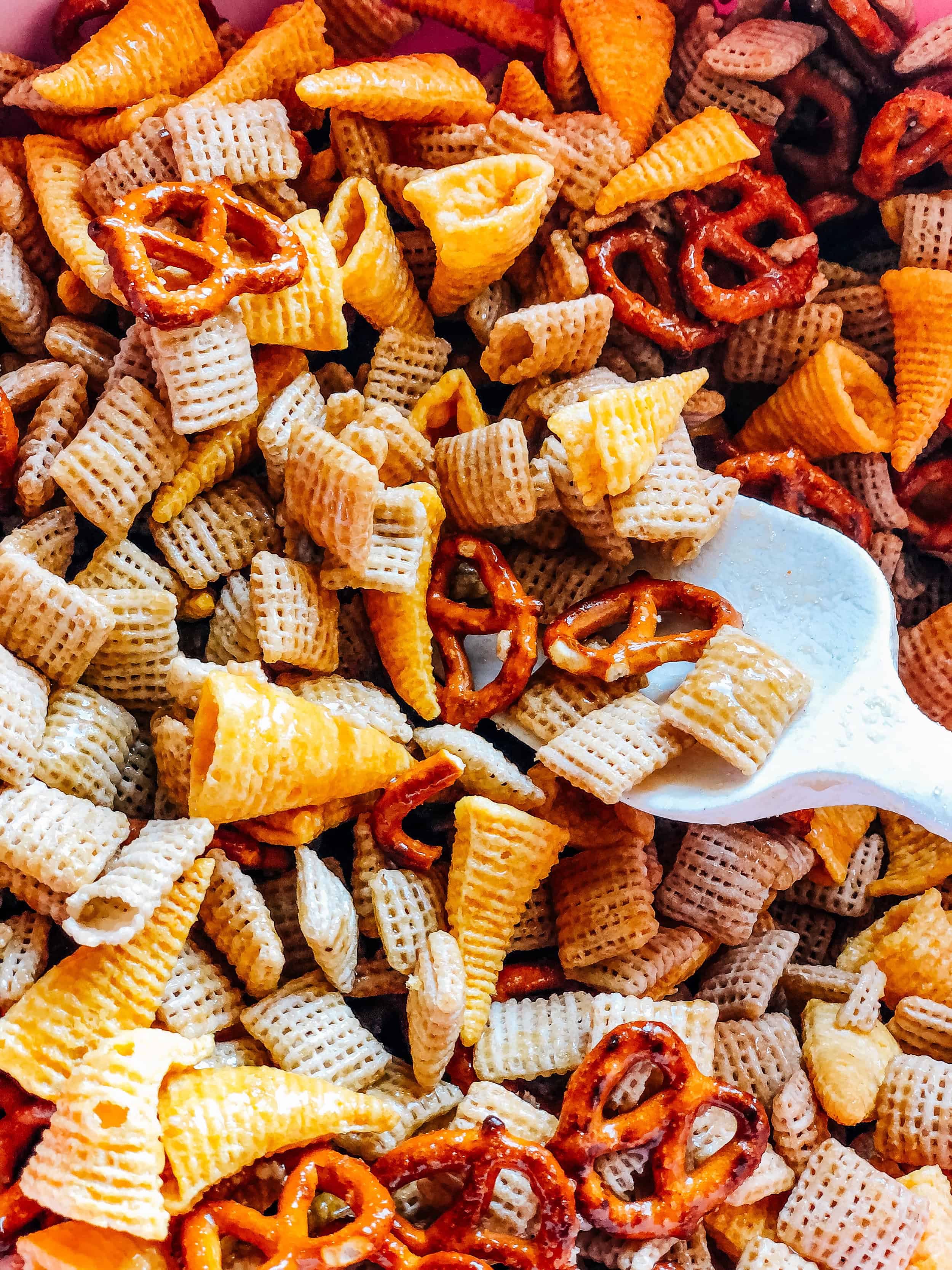 Up close picture of the brown sugar sauce coated rice squares, pretzels and Bugles.