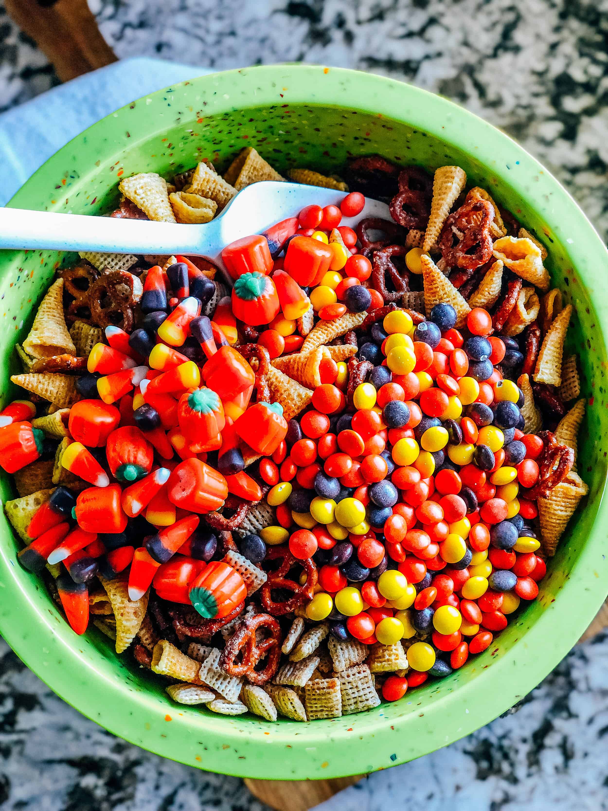 Add the candy items on top of the baked rice squares, pretzels, and Bugles.