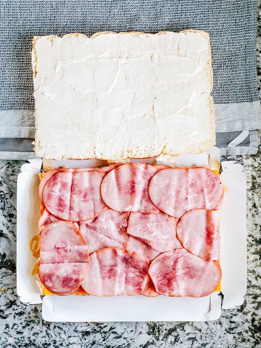 Jambon de charcuterie tranché disposé sur les mini-burgers.