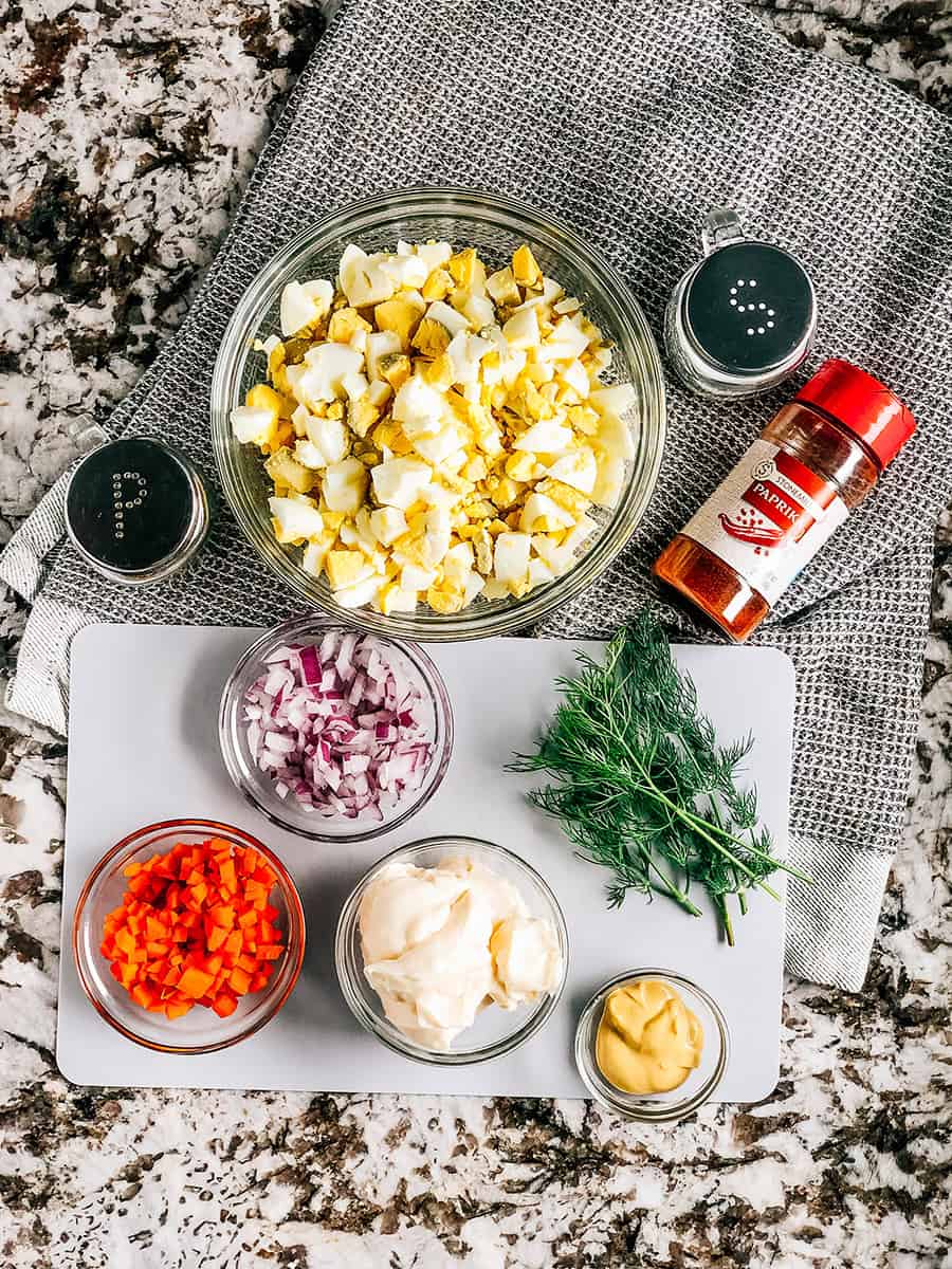 Les ingrédients pour la meilleure salade d'œufs : œufs durs hachés, carotte en dés, oignon rouge en dés, Miracle Whip, moutarde de Dijon, paprika, sel et poivre.