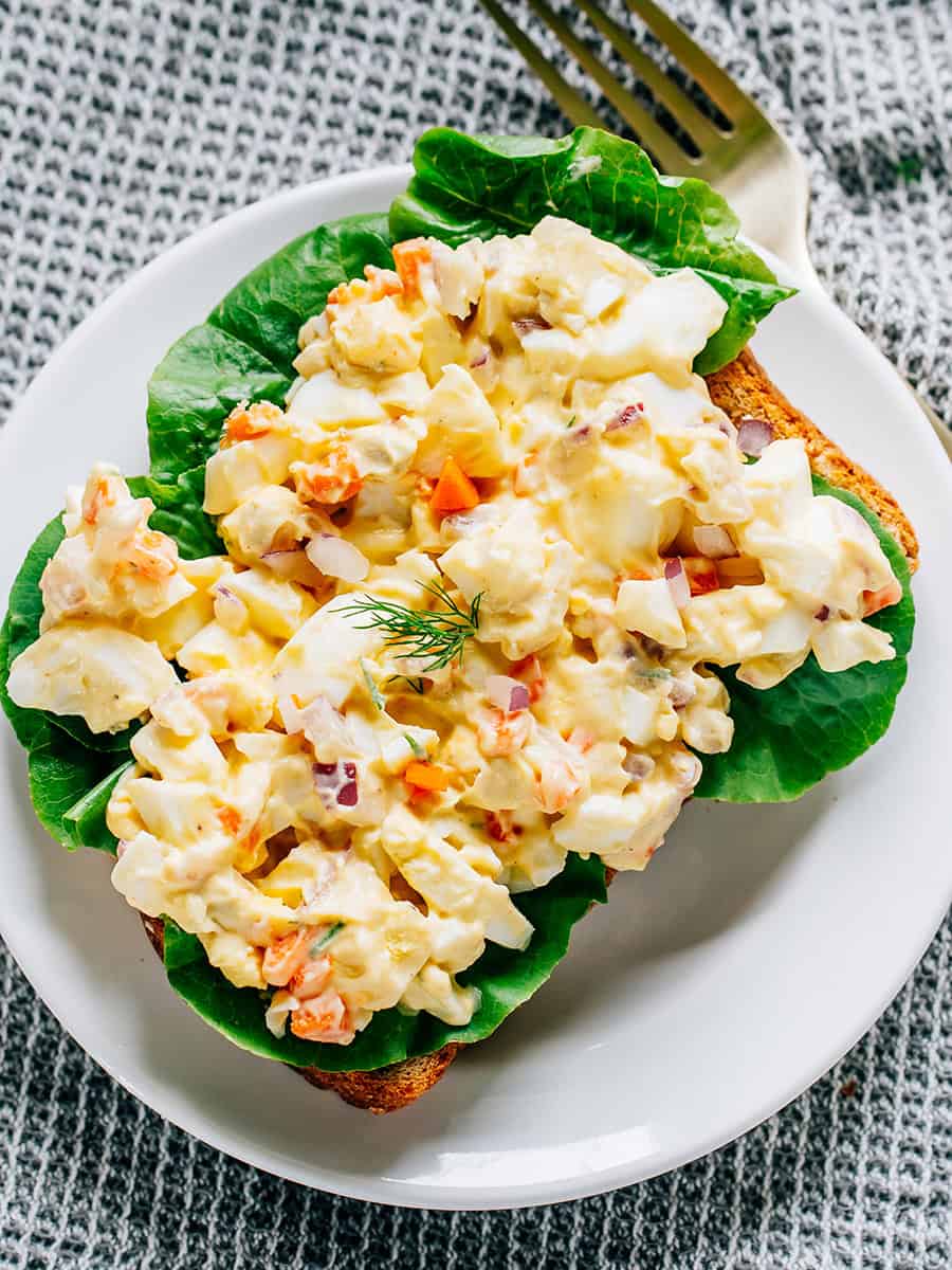 Salade d'œufs sur du pain beurré de blé et de la laitue de jardin.