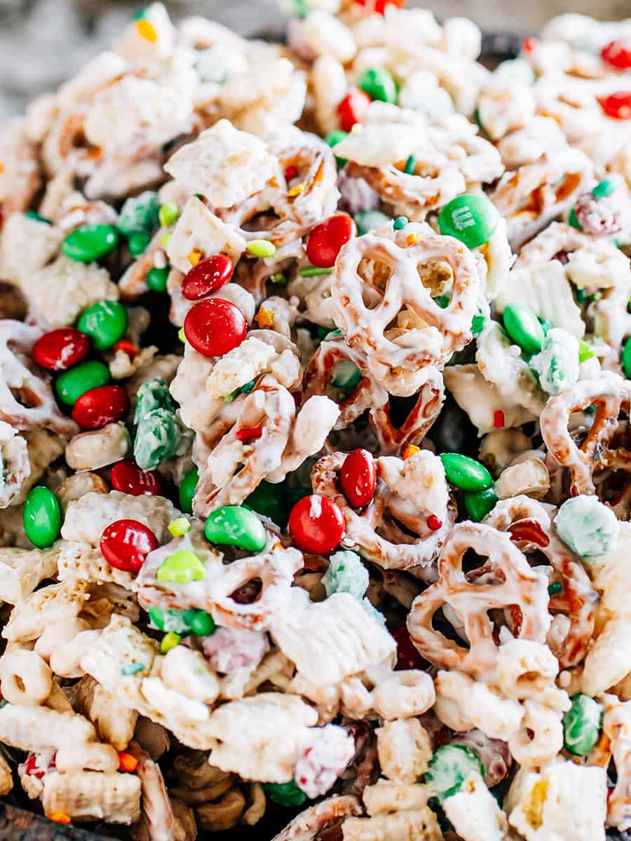 Bretzels enrobés de chocolat blanc, carrés de riz et Cheerios mélangés avec des M&Ms et des paillettes de Noël pour un en-cas amusant que les enfants adorent !